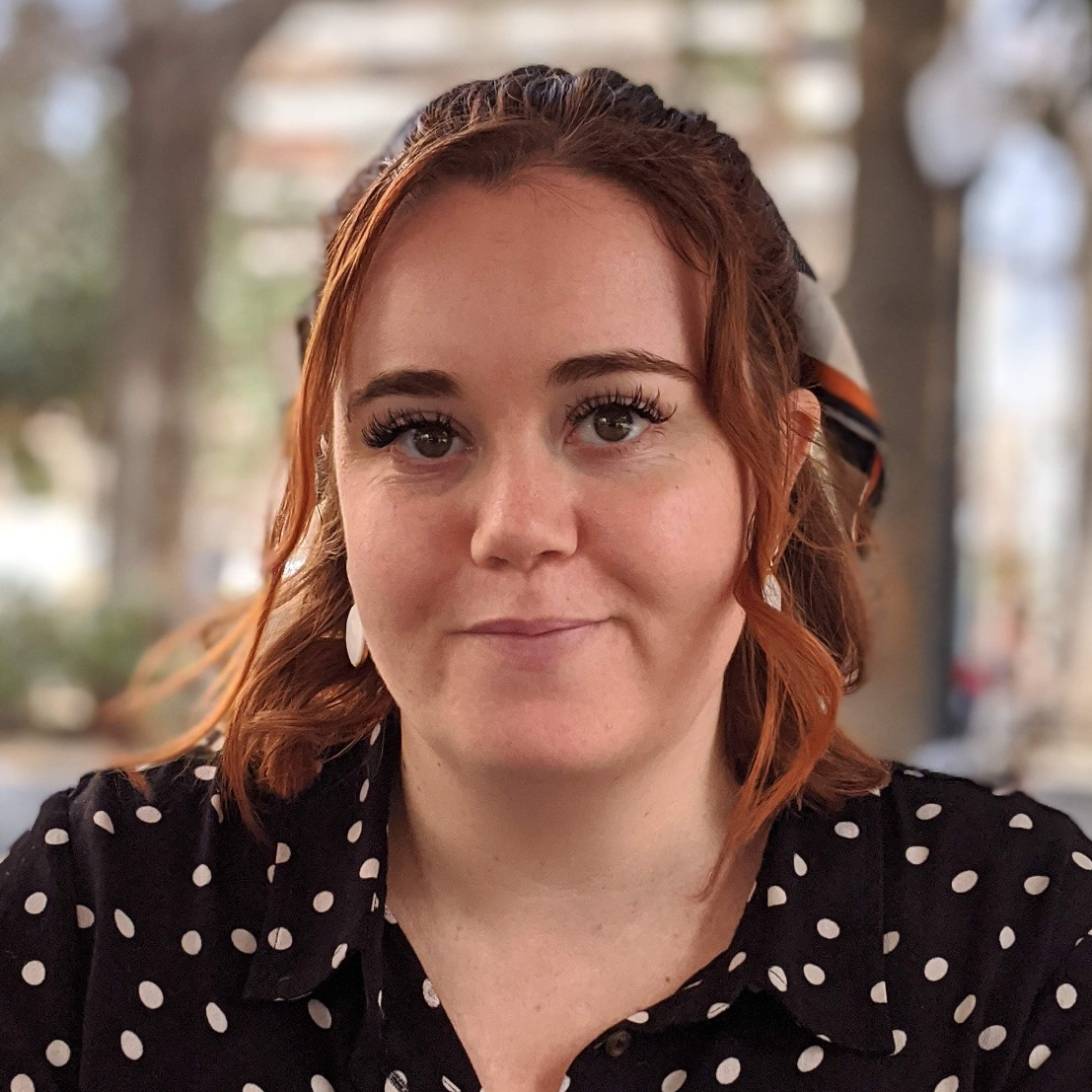 Jessica is pictured looking towards the camera. She is wearing a black polka-dot dress and has a bow in her hair.