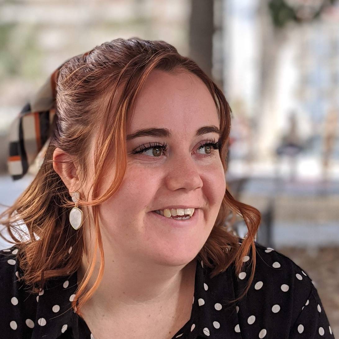 Jessica is pictured looking off to the side of the camera. She is wearing a black polka-dot dress and has a bow in her hair.